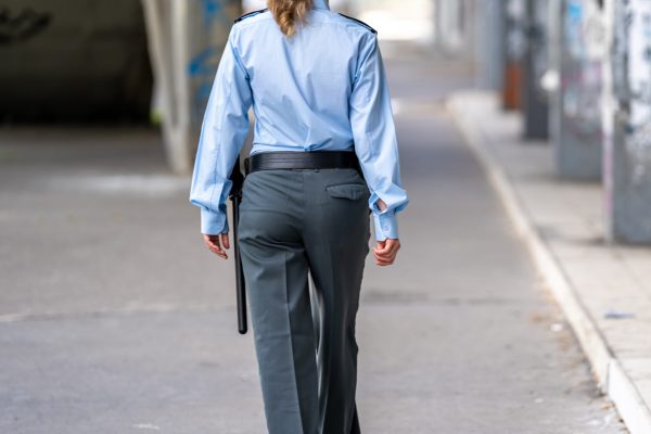 policewoman in uniform walking around the city district policeman in uniform walking around the city